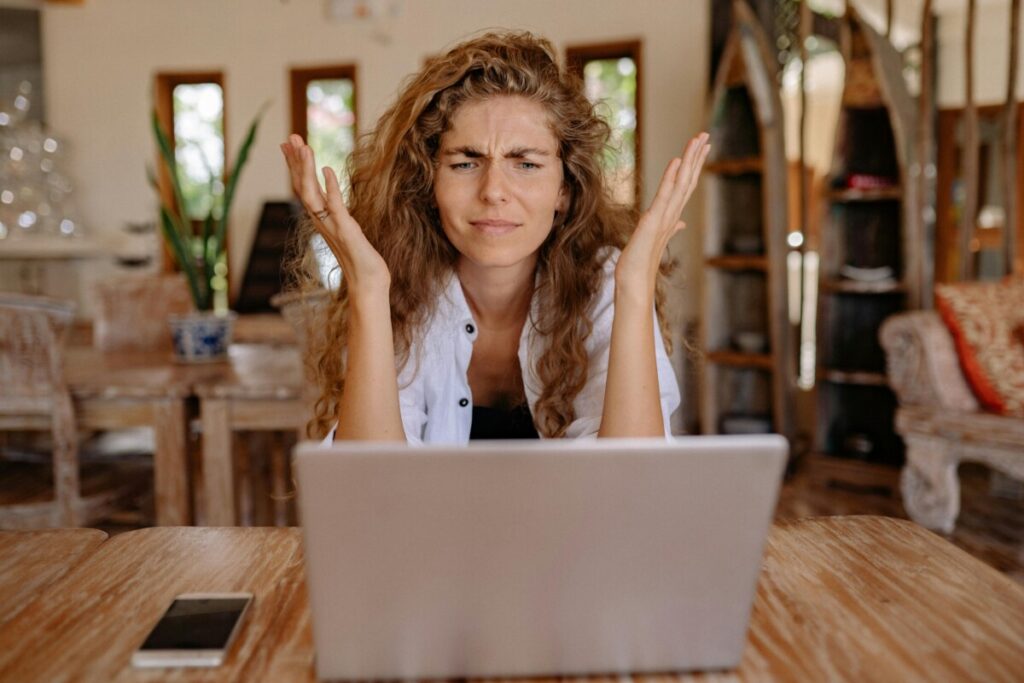 o imagine cu o femeie care se uită confuz spre ecranul unui laptop